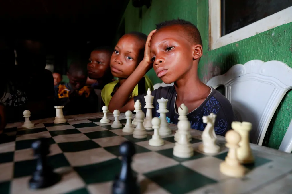 Děti hrají šachy v komunitním centru v Makoko v Lagosu v Nigérii. Centrum má s šachy pozitivní zkušenost. Dle vyjádření vedoucích se v místě snižuje kriminalita a děti mají lepší vztah k učení