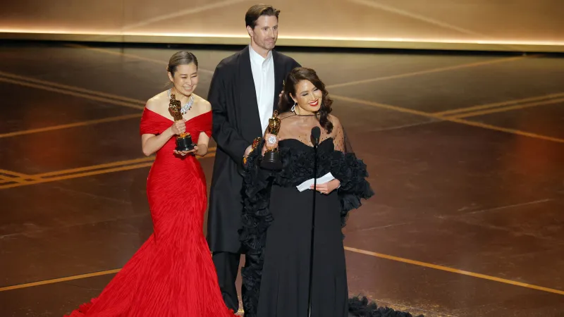 Režiséři Maggie Kangová a Chris Appelhans a producentka Michelle L.M. Wong přebírají Oscara za nejlepší animovaný film pro K-pop: Lovkyně démonů