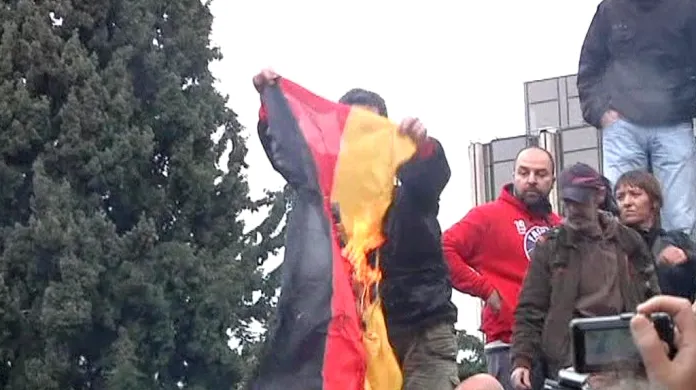 Řečtí demonstranti pálí německou vlajku