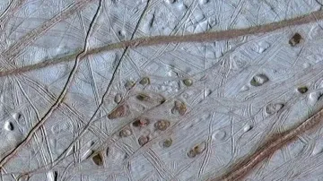 Detail povrchu měsíce Europa a ledové krusty, která podle hypotézy NASA pokrývá oceán ukrytý pod ní