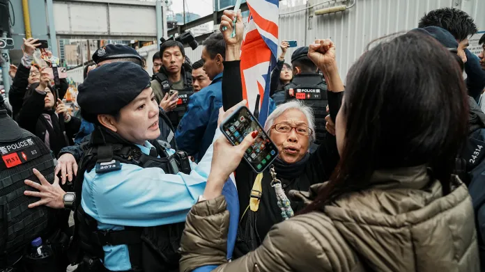 Bezpečnostní personál před soudem West Kowloon Magistrates' Court během procesu s mediálním magnátem Jimmym Laiem zajištuje jeho příznivce
