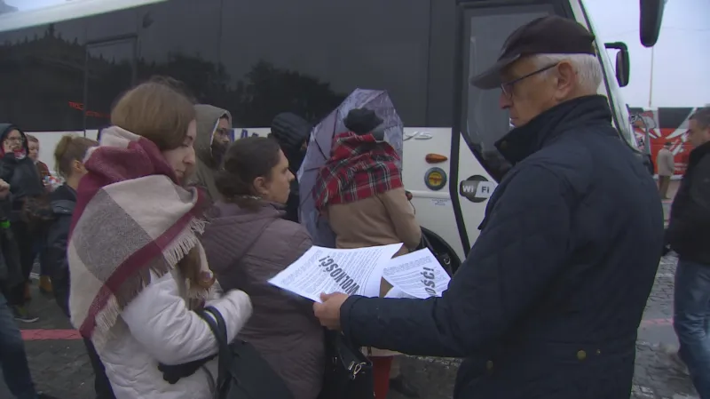 Lidé rozdávají letáky, které po sobě nechal popálený muž