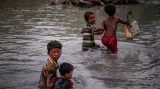 Rohingští sourozenci, kteří prchli před násilím v Myanmaru přes řeku Naf River do Bangladéše si pomáhají na posledních metrech strastiplné cesty