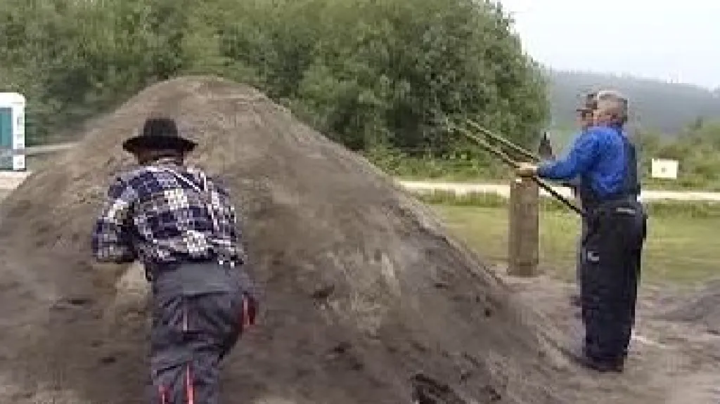 Uhlíři obkládají milíř hlínou