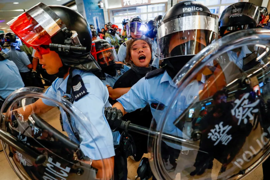 Pořádková policie v Hongkongu zadržela ženu, když protivládní demonstranti blokovali stanici hromadné dopravy Sha Tin. Zdejší demonstrace proti nedemokratickému vývoji jsou nejdelším souvislým protestem poslední dekády. Fotografie z 25. září 2019