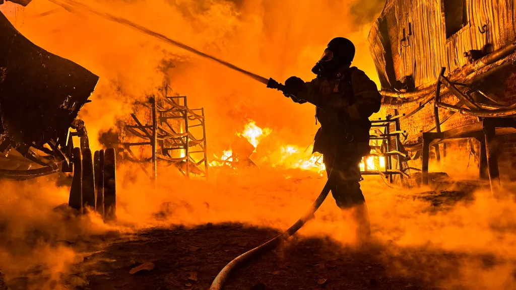 Hasič likviduje v Charkově požár způsobený ruským útokem