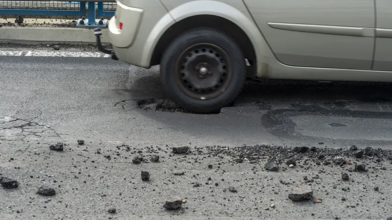 Povrch vozovky je plný výtluků