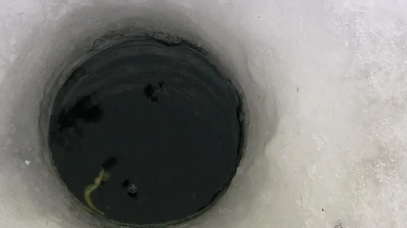 Rybolov na zamrzlém rybníku