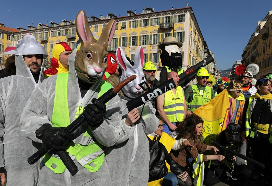 Demonstranti hnutí „žluté vesty“ v maskách na karnevalu v Nice