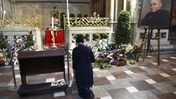 Žena klečící u rakve s ostaky kardinála Josefa Berana před uložením do sarkofágu