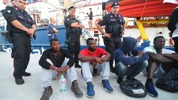 Italští policisté kolem migrantů, kteří vystoupili z lodě