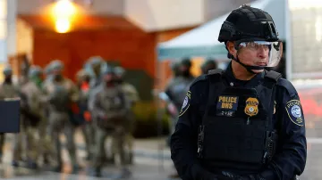 Policista Federální ochranné služby střeží bránu zařízení ICE v Portlandu (26. října 2025)