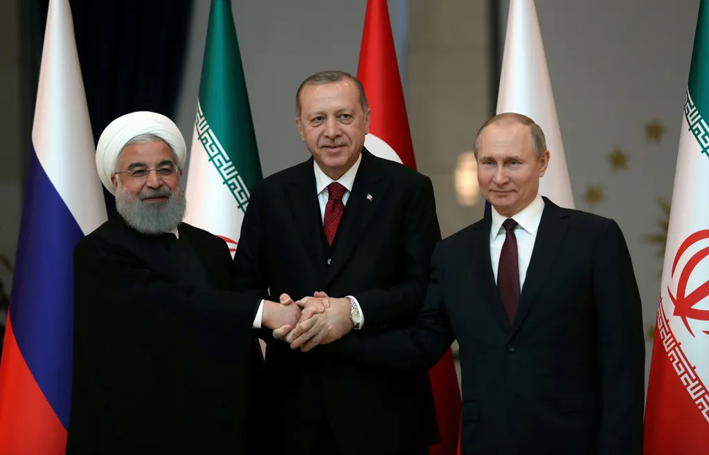 Íránský prezident Hassan Rouhání, turecký prezident Tayyip Erdogan a ruský prezident Vladimir Putin pózují se spojenýma rukama před jejich společným jednáním v Ankaře