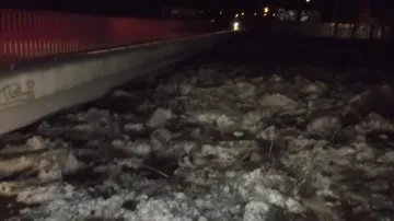Hladina zamrzlé řeky dosáhla až k mostu