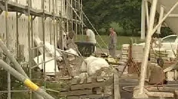 Stavební dělníci dokončují základy bytového domu