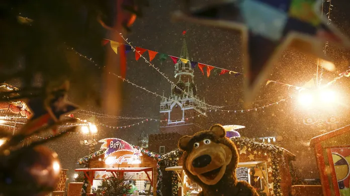 Pouliční performer v kostýmu medvěda na vánočních trzích na Rudém náměstí v Moskvě.