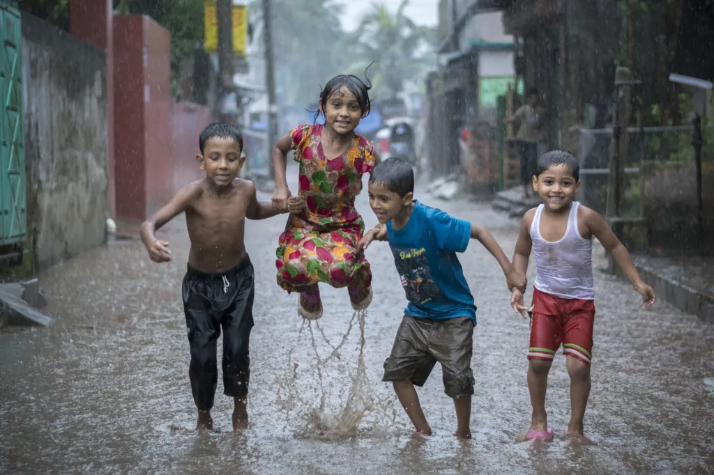 Fotografie ze souboru vítěze v kategorii 15–18 let Fardina Oyana: Sadar, Bangladéš. „Když jsem viděl tyhle děti, jak se radují a hrají si v dešti, přikryl jsem fotoaparát plastovým sáčkem a vyběhl za nimi do ulic. Tančili jsme spolu, smáli se a dováděli v dešti.“