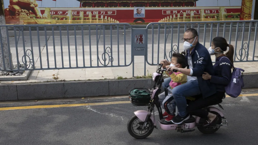 Obyvatelé Wu-chanu před propagandistickým plakátem čínské vlády