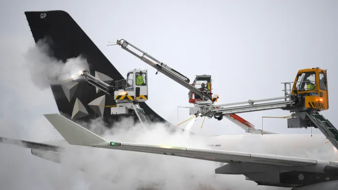 Technici odstraňují námrazu z letadla na frankfurtském letišti