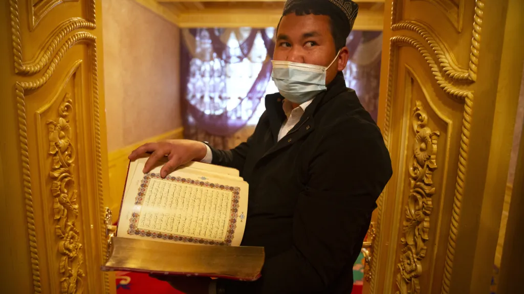 Ujgurský duchovní drží v ruce korán