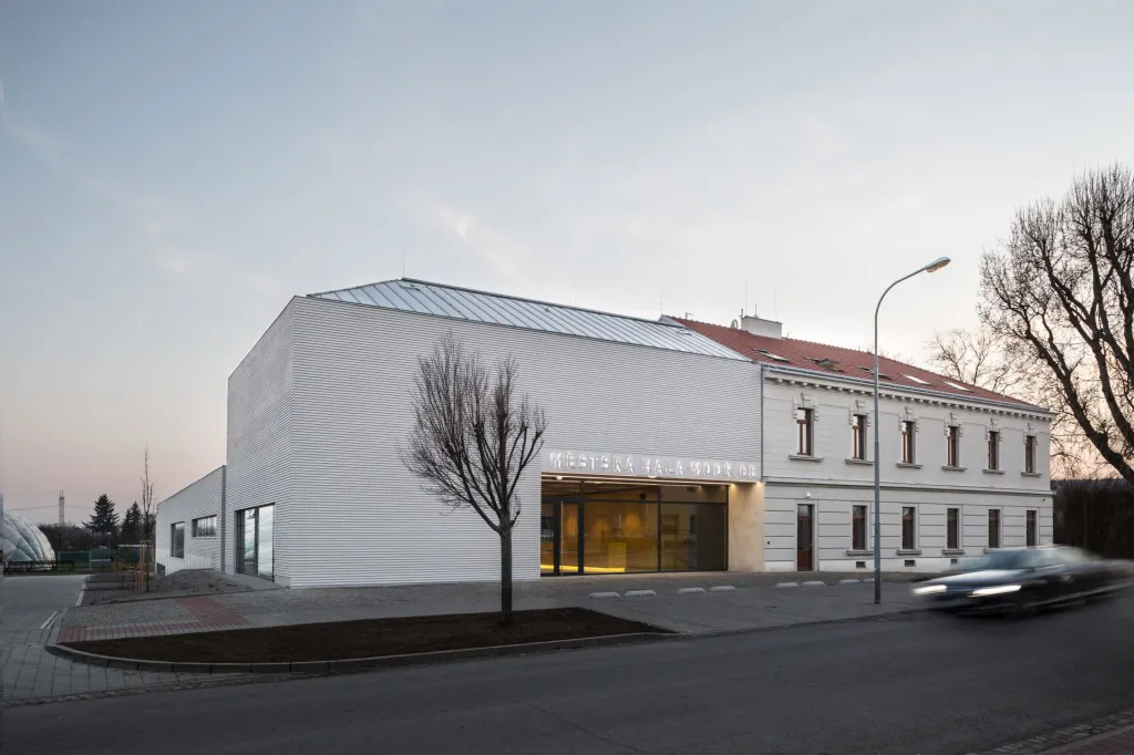Objekt sportovní haly, s ambicí sloužit i jako komunitní centrum, museli autoři vklínit mezi železniční koridor a základní školu