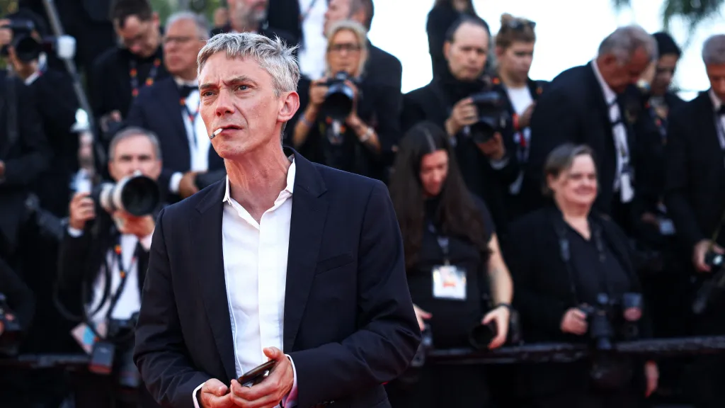 Francouzský herec Swann Arlaud kouří na červeném koberci festivalu v Cannes