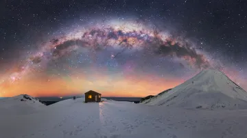 Mléčná dráha nad chatkou Syme a hora Taranaki