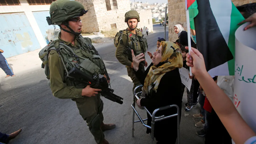 Izraelští vojáci hovoří v Hebronu s palestinskou ženou