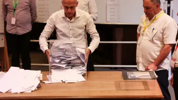 Člen volebního kolegia v den hlasování otevírá volební urnu při výběru kandidátů