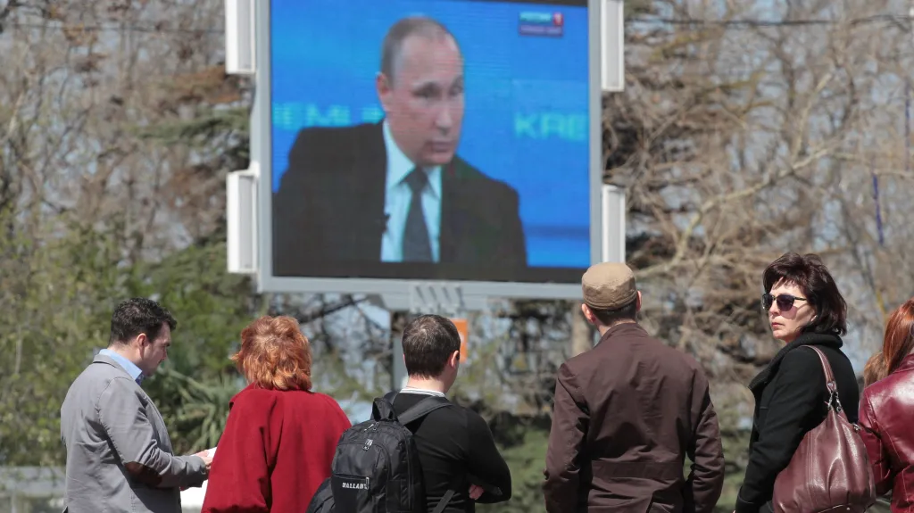 Obyvatelé Krymu sledují na obrazovce ruského prezidenta
