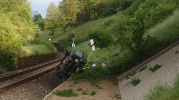 Řidič s autem spadl z mostu do kolejiště