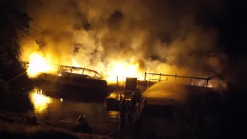 Noční záběry hořící lodi Dyje