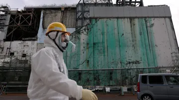 Pracovník prochází kolem reaktoru ve Fukušimě