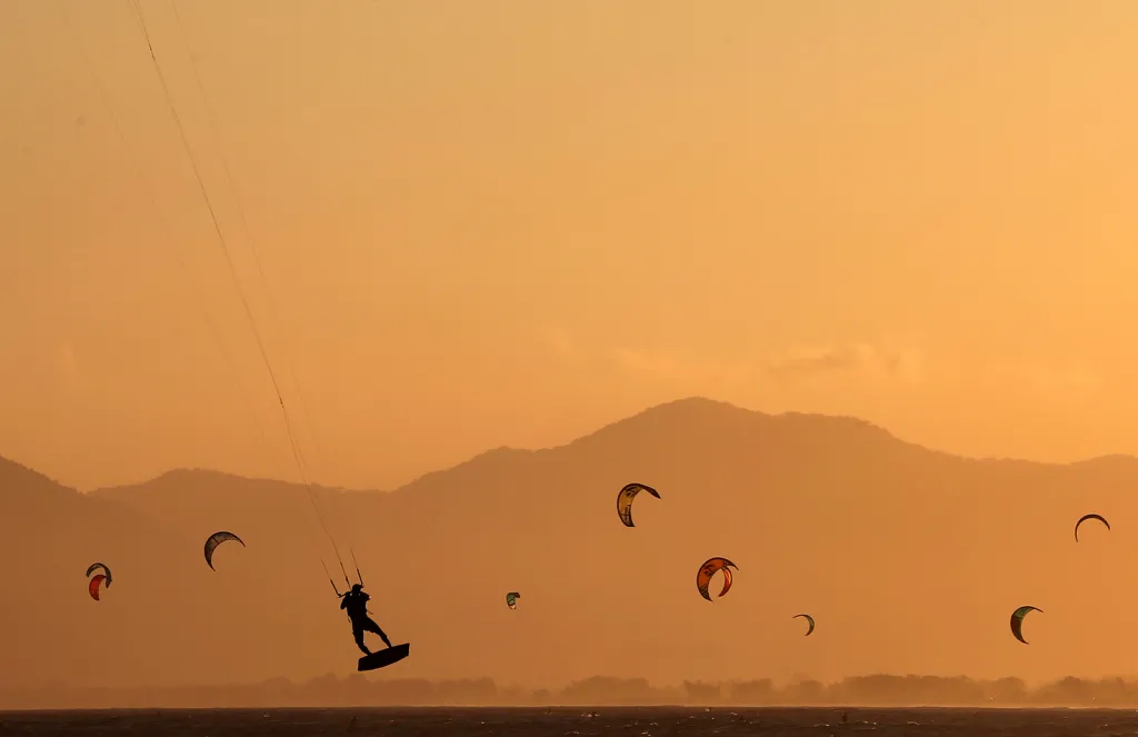 Kitesurfeři na brazilské pláži Barra da Tijuca v Riu de Janeiro