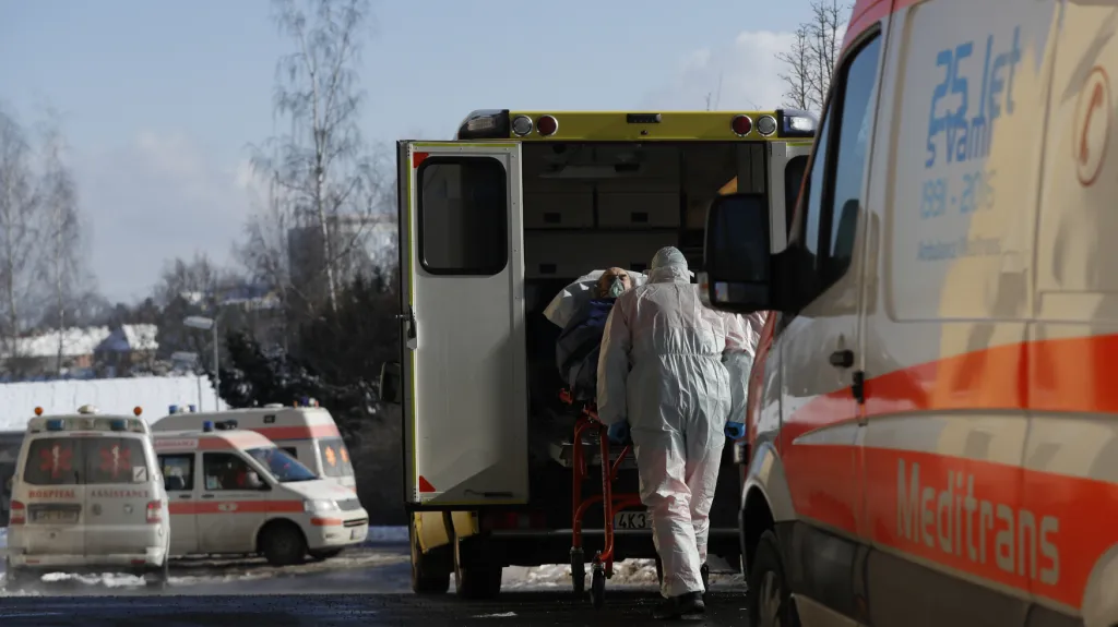 Zdravotníci převážejí pacienta s covidem-19 z přetížené chebské nemocnice
