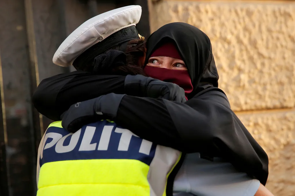 Objetí s policistou během demonstrací proti zákazu nošení burek v dánské Kodani