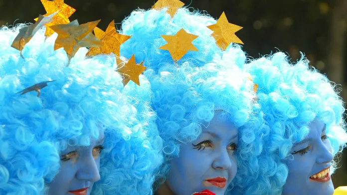 Tři ženy oblečené jako vlajka Evropské unie se účastní karnevalu na Merrion Square v Dublinu
