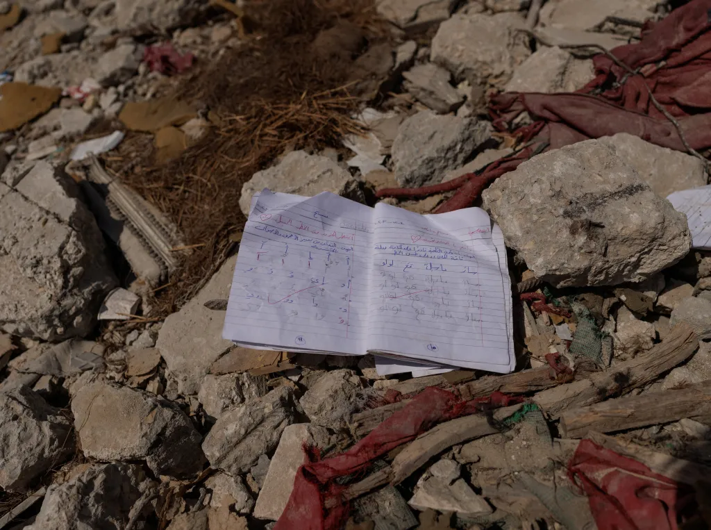 Školní sešit v troskách domu ve městě Tyre na jihu Libanonu, který byl zasažen během izraelského útoku