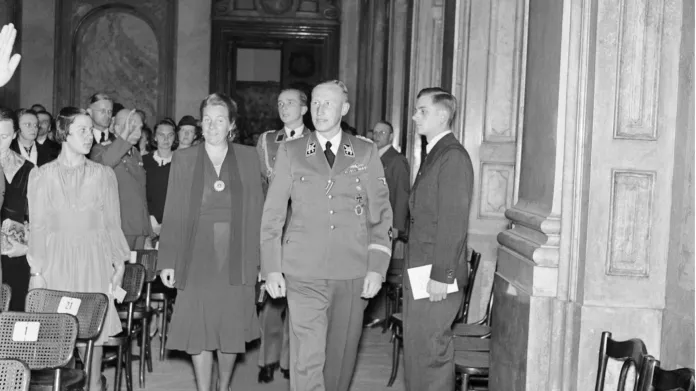 Manželé Heydrichovi přicházejí na koncert do Valdštejnského paláce. Je večer 26. května 1942.