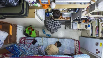 Únor 2015. Byt o výměře cca 6 čtverečních metrů s měsíčním nájmem 487 dolarů. V takových bydlí v Hong-Kongu celé rodiny s nízkým příjmem a těžším uplatněním na místním pracovním trhu. Městský rozpočet na rok 2015 zahrnoval opatření k eliminaci tohoto způsobu bydlení pro pracující.