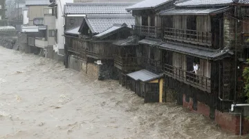 Vlivem silných dešťů došlo k vylití několika řek. Na snímku je muž, který se dívá ze svého domu na stoupající řeku Isuzu.