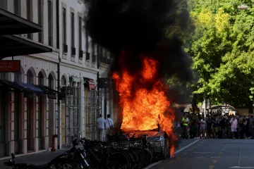 Demonstranti proti summitu G7 zapálili auto a rozbili okno banky