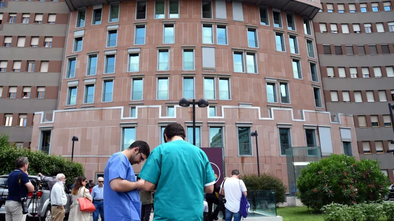 Příznivci Berlusconiho a novináři před nemocnicí San Raffaele