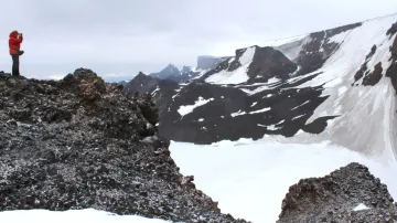 Člen expedice dokumentující sněhová pole spadající z hory Lachman Crags