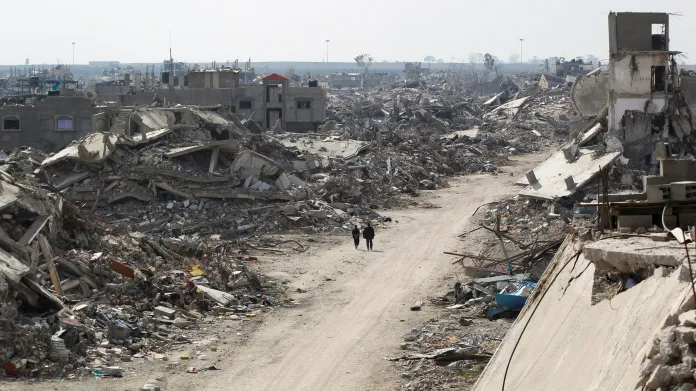 Palestinci procházejí kolem trosek budov zničených během izraelské ofenzivy v Rafahu na jihu Pásma Gazy