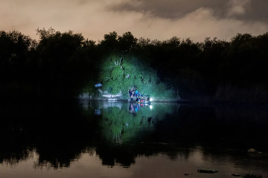 Rodiny migrantů, které žádají o azyl, se naloďují na nafukovací člun na mexické straně řeky Rio Grande. Přes řeku se pokouší dostat do Texasu v USA