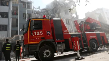 Hasičský vůz před poškozenou budovou