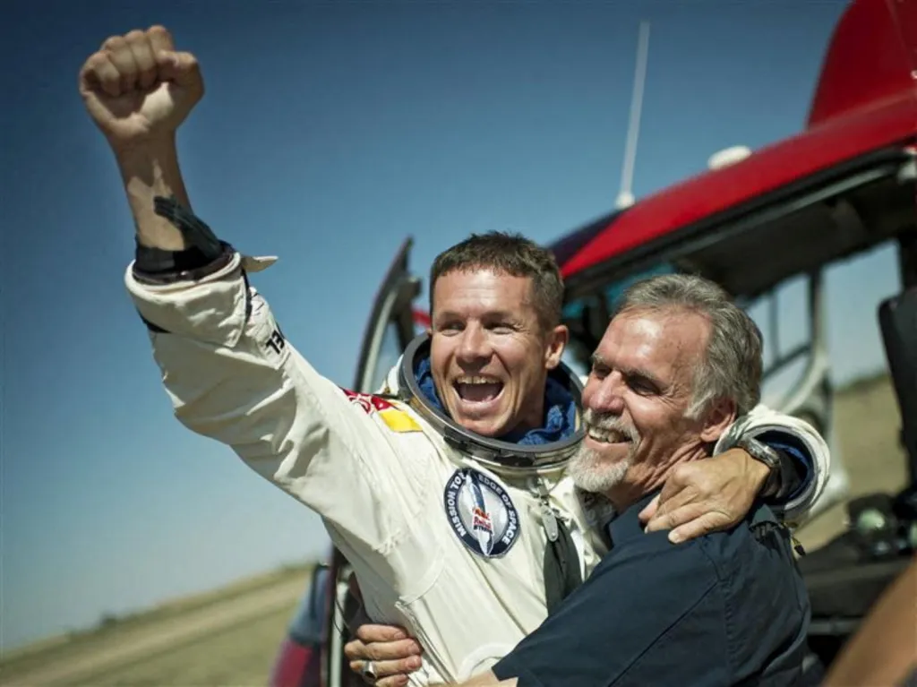 Pilot Felix Baumgartner a technický ředitel projektu Art Thompson oslavují úspěšný seskok ze stratosféry