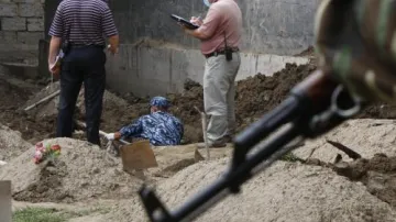 Vojáci zkoumají hroby nedávných obětí