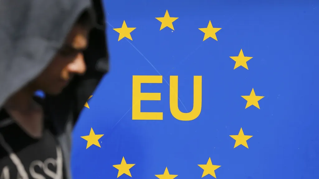 Jeden z migrantů prochází v chorvatském Tovarniku kolem cedule označující hranice Evropské unie